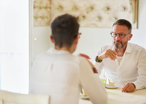 Two men sat looking at eachother across the table.